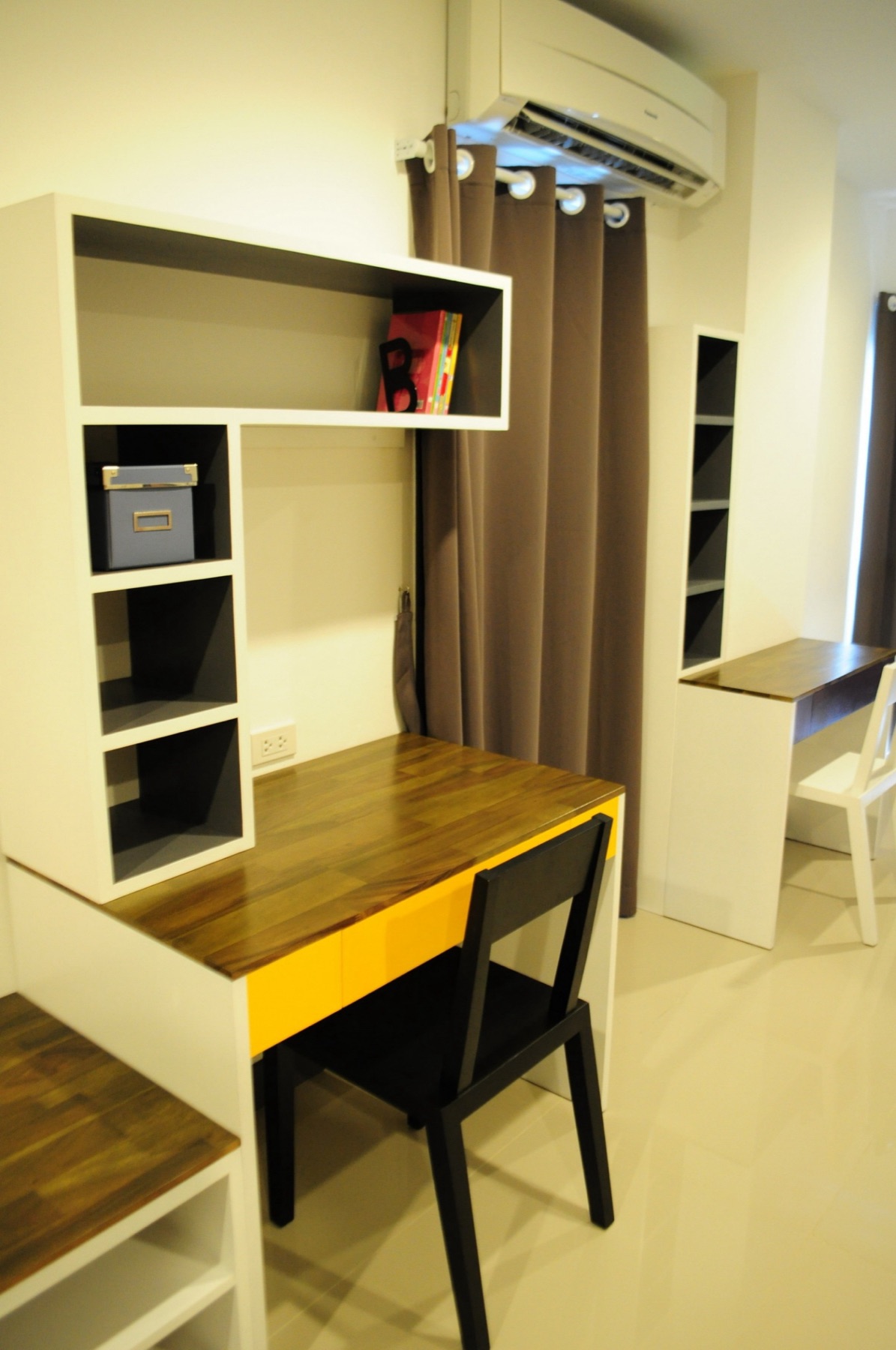 โต๊ะทำงานสองจุด ชั้นวาง และพื้นที่จัดเก็บภายในห้อง Deluxe