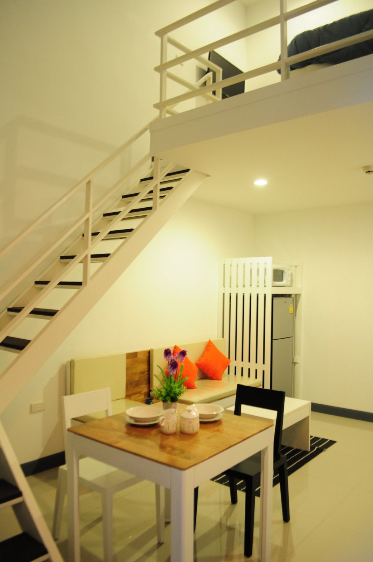 พื้นที่สองชั้น บันได โต๊ะรับประทานอาหาร และมุมนั่งเล่นของห้อง Loft