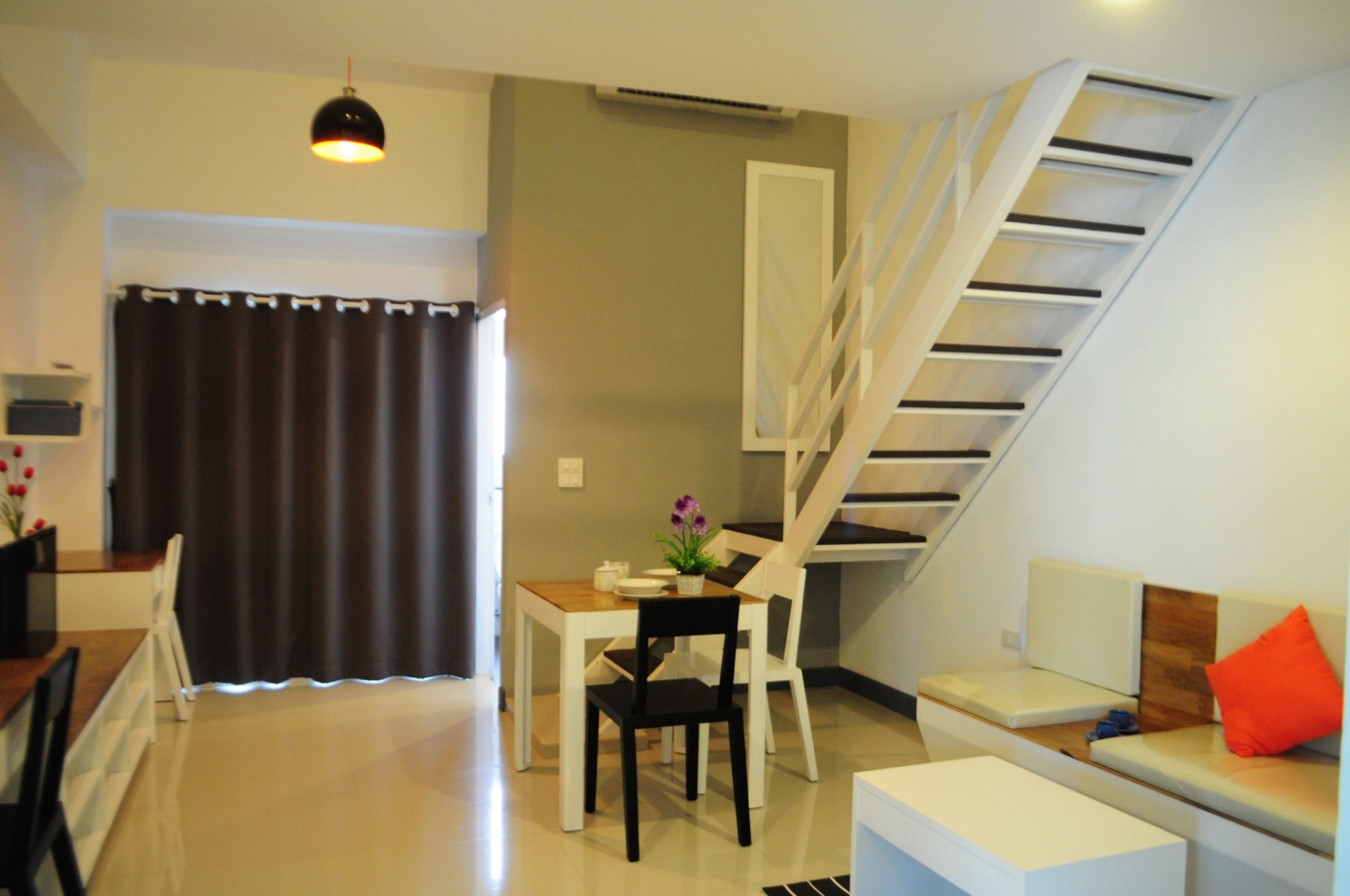 พื้นที่นั่งเล่น โต๊ะรับประทานอาหาร และบันไดขึ้นชั้นลอยของห้อง Loft