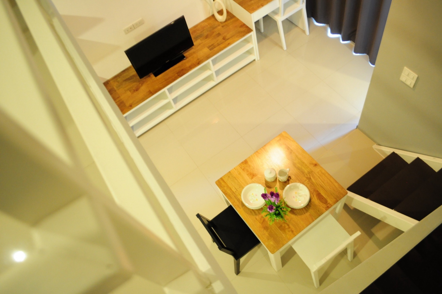 มุมมองพื้นที่รับประทานอาหารและพื้นที่นั่งเล่นจากชั้นลอยของห้อง Loft